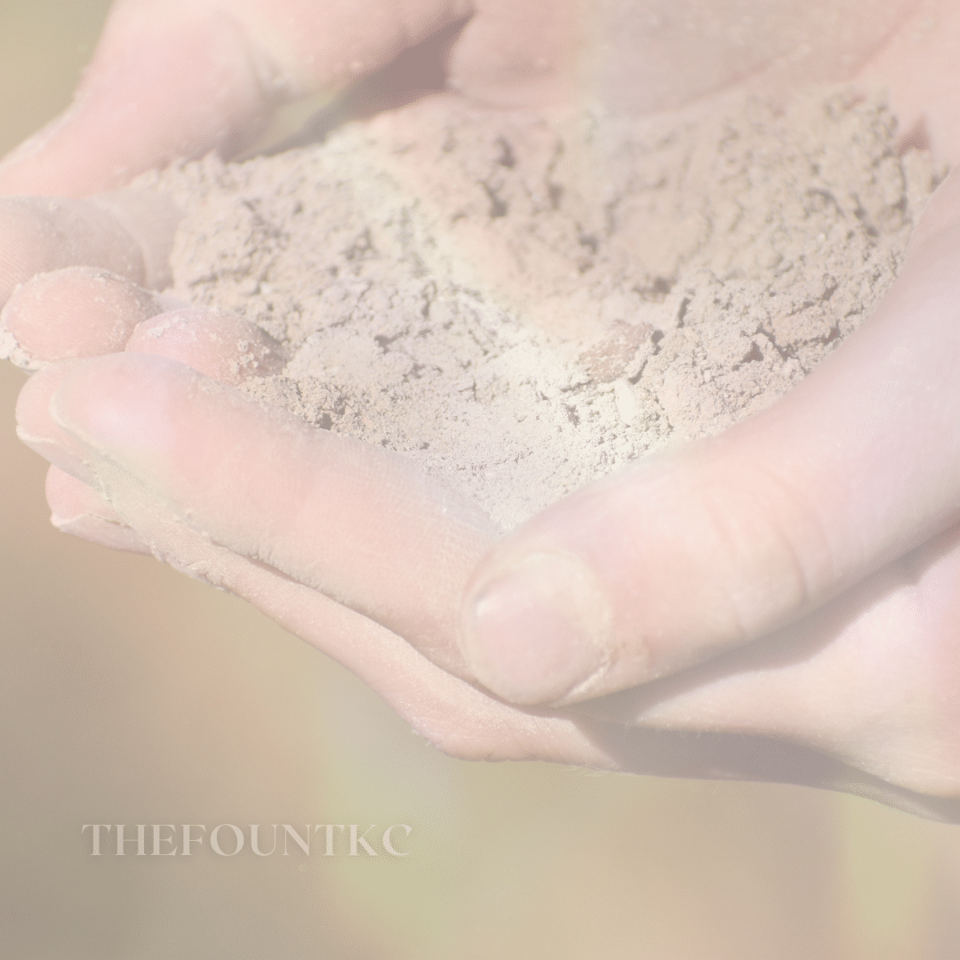 A hand cupping a pile of dirt representing a compassionate God lifting us from the weight of our sins